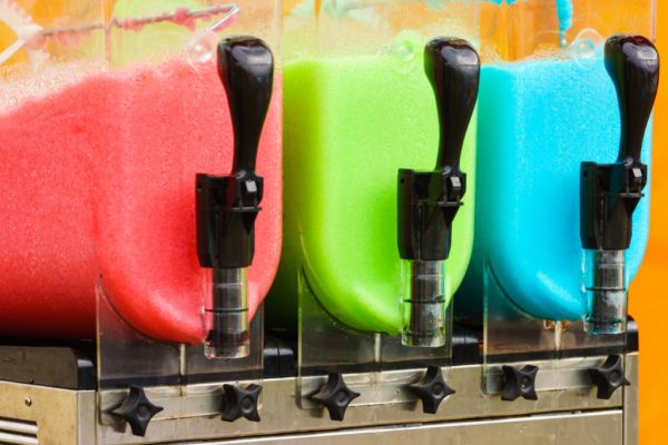 close up of 3 commercial sized slushie makers with 3 different colored slushies in them