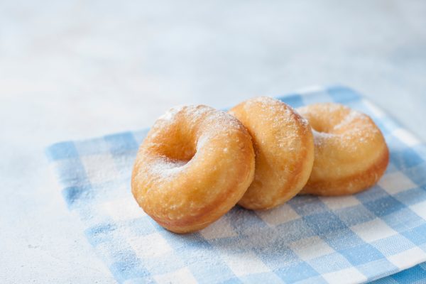 fresh made donuts on a blue and white gingham napkin