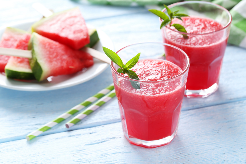 two glasses of watermelon slushies and a plate of watermelon slices
